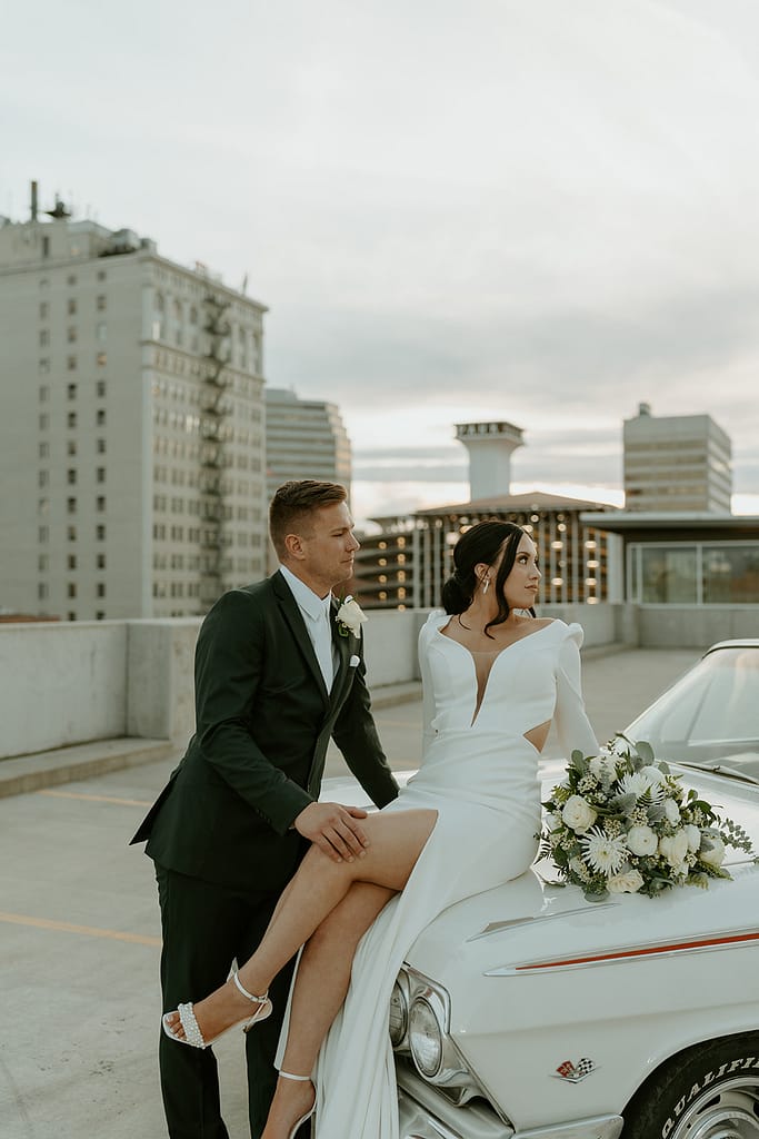 bride and groom with classic car on the rooftop after downtown elopement ceremony