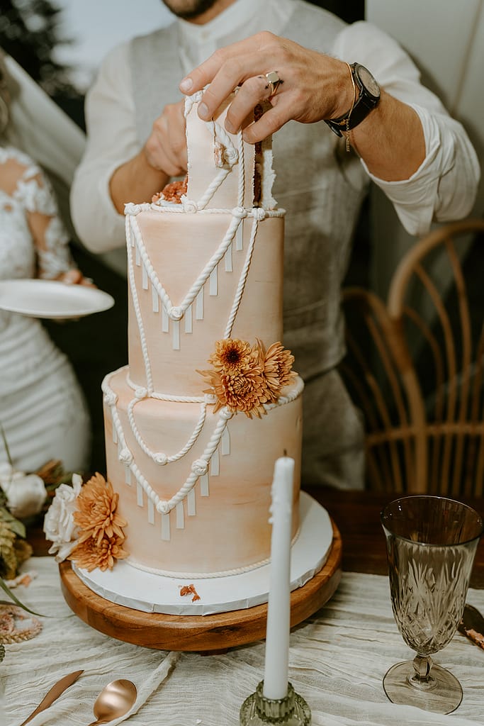 bride and groom cutting boho wedding cake