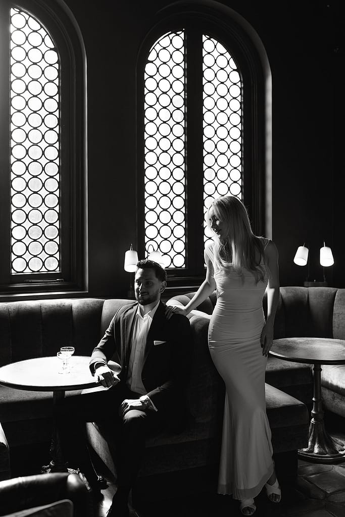 Engaged couple sharing a sweet moment in the moody-lit bar at Palihouse Santa Monica.