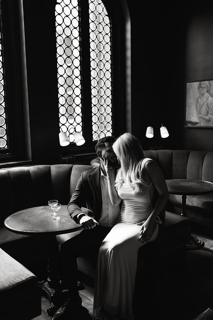Engaged couple sharing a sweet moment in the moody-lit bar at Palihouse Santa Monica.