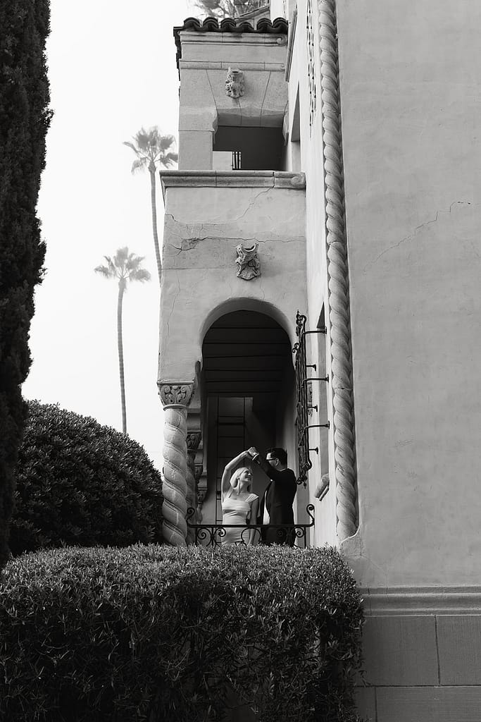 Bride and groom-to-be standing on a charming Tuscan-style balcony at Palihouse Santa Monica.