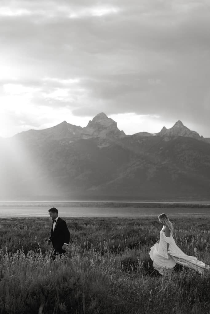Couple in a vast field with Tetons in background for their Jackson Hole elopement