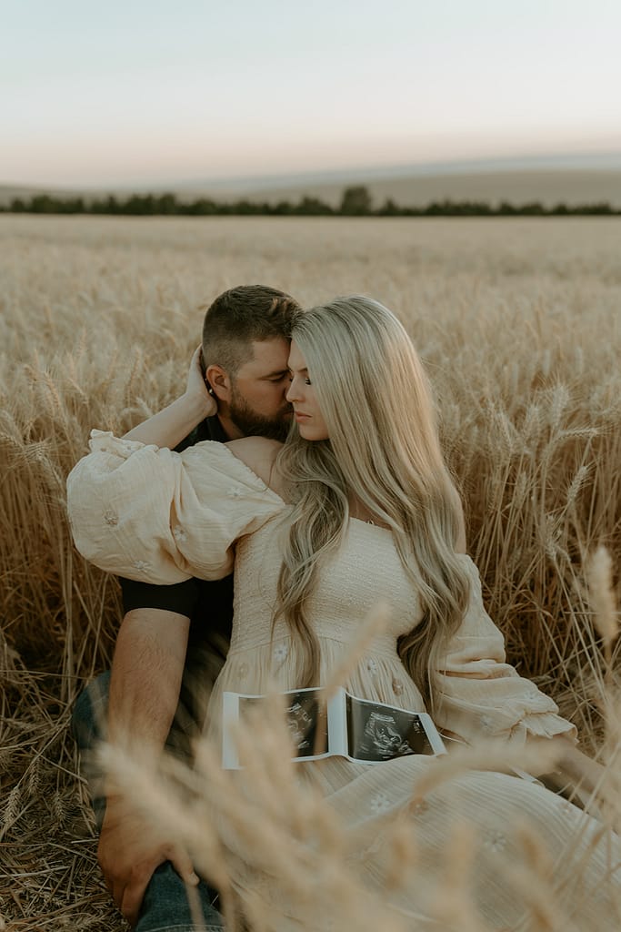 Haley and Tate share a tender moment, the setting sun creating a romantic backdrop for their pregnancy reveal photo shoot.